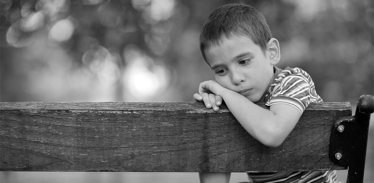 Black and White photo of Little boy on bench